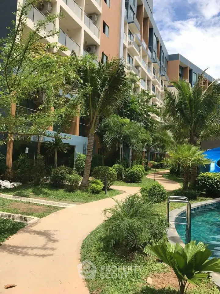 Luxurious apartment complex with lush gardens and inviting pool area for relaxation.