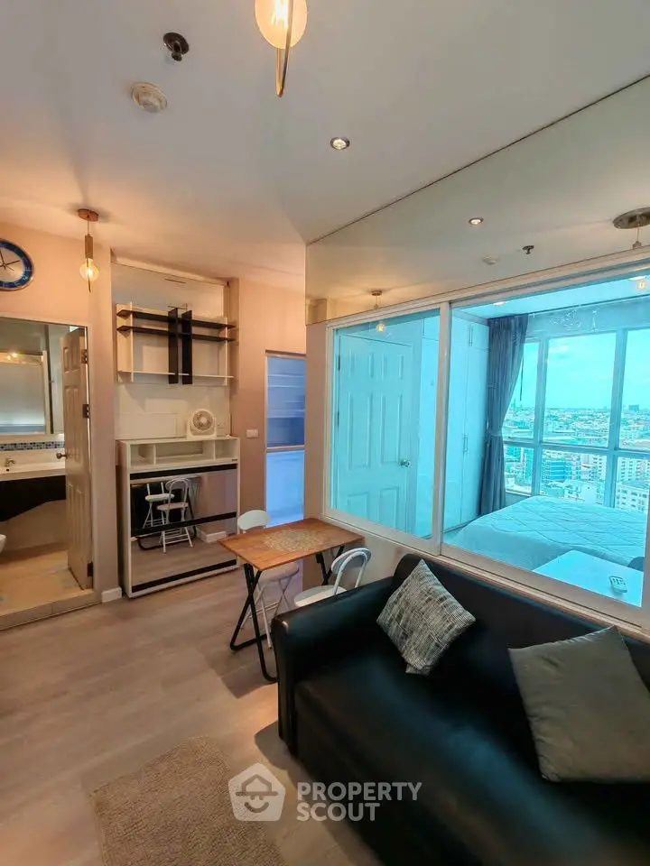 Modern living room with large windows offering stunning city views, cozy seating, and stylish decor.