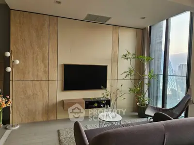 Modern living room with large windows and stylish decor in a high-rise apartment.