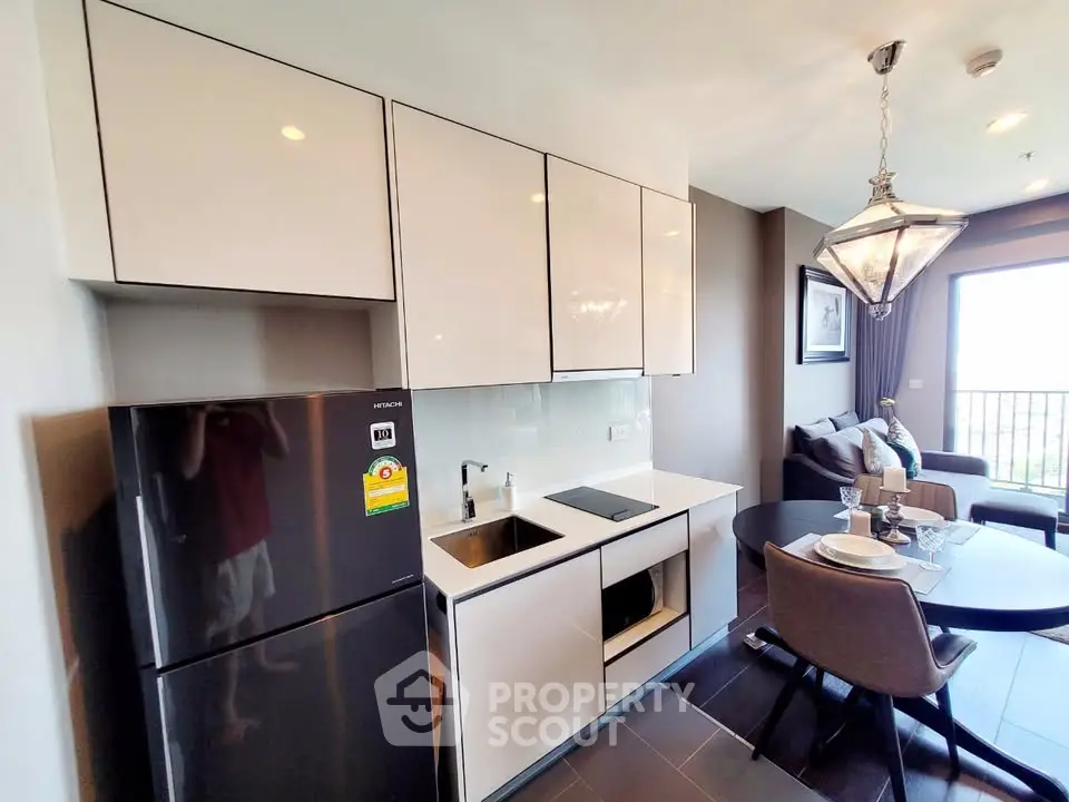 Modern kitchen with sleek cabinetry and dining area in stylish apartment
