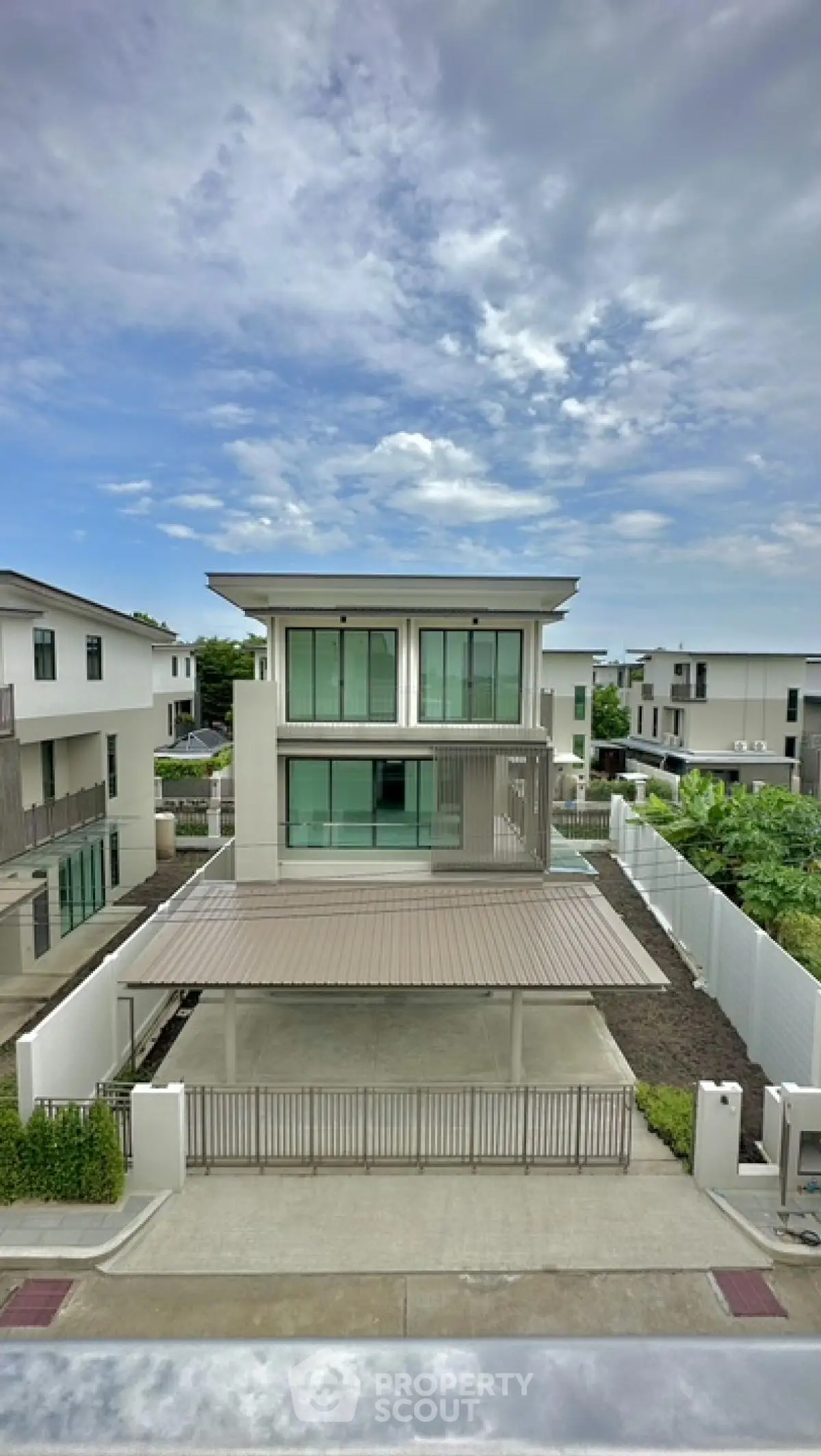 Modern two-story house with spacious driveway and contemporary design in a serene neighborhood.
