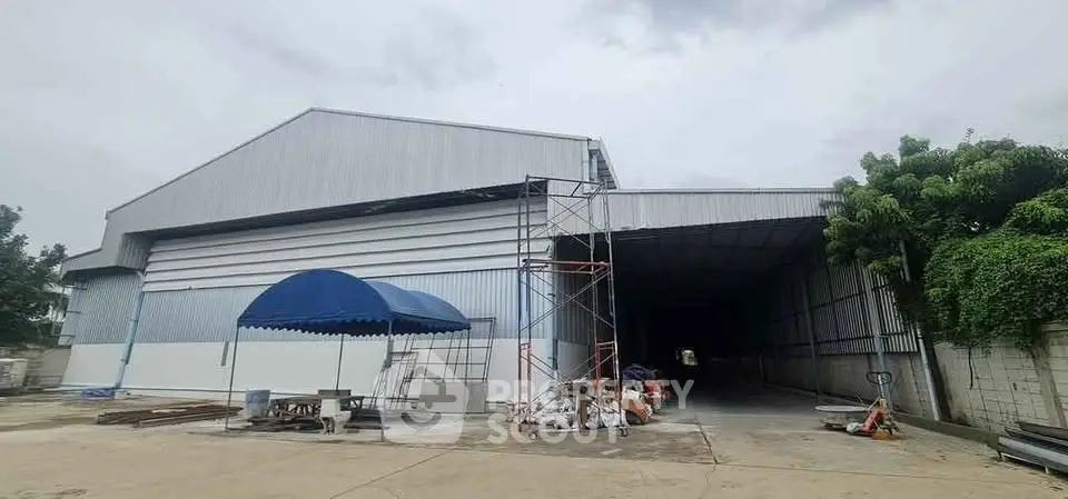 Spacious industrial warehouse with large open entrance and ample outdoor space.