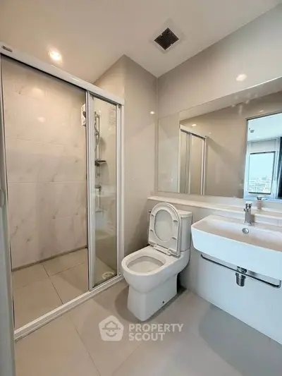 Modern bathroom with sleek shower and elegant fixtures in a contemporary apartment.