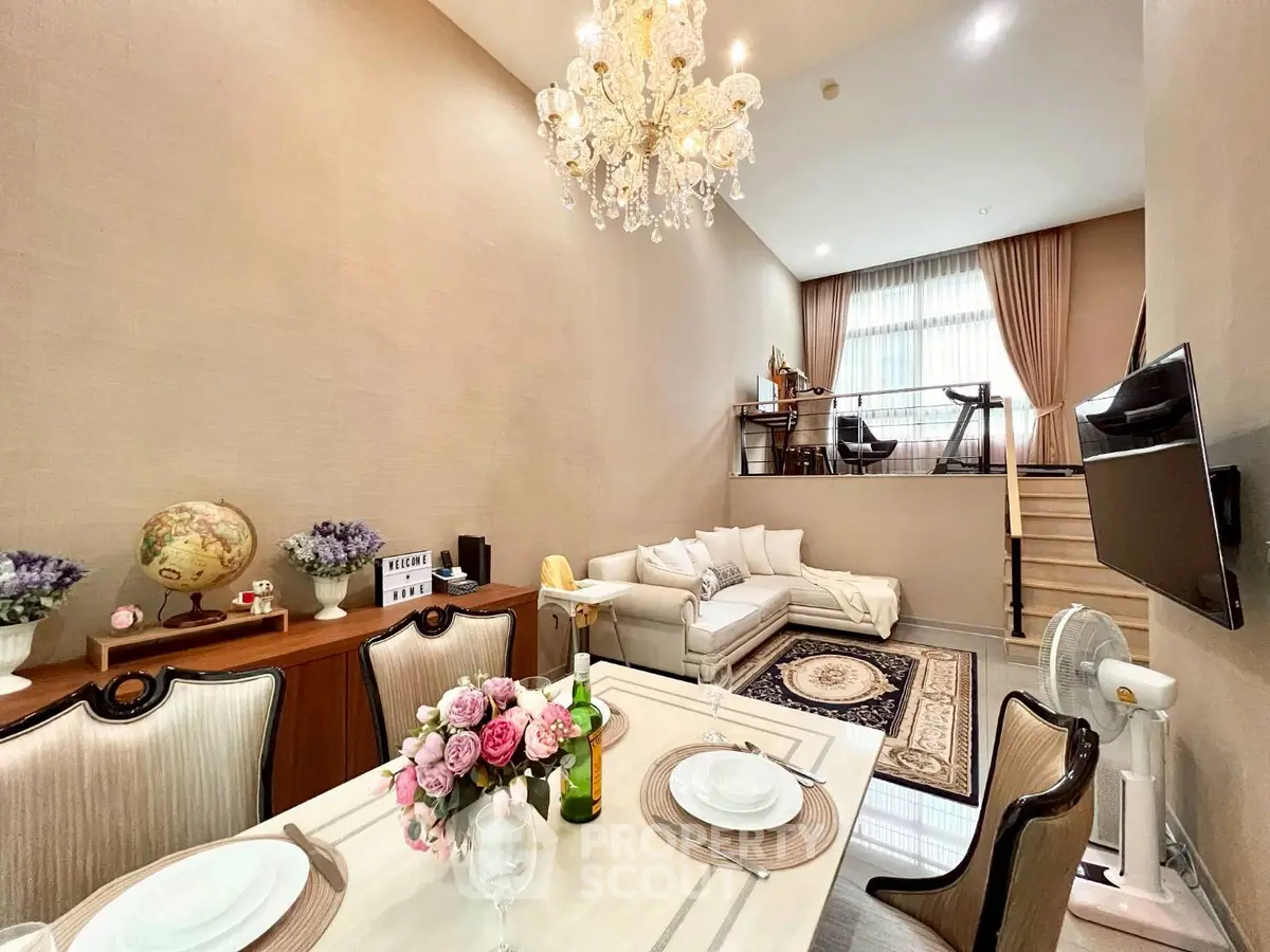 Luxurious living room with elegant chandelier and cozy seating area in modern duplex apartment.
