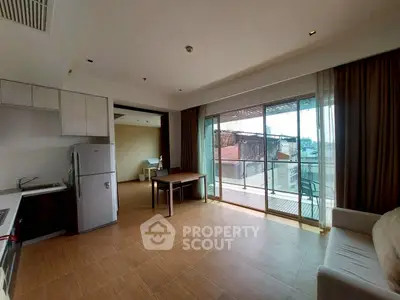 Spacious open-plan living room with balcony and modern kitchen in urban apartment