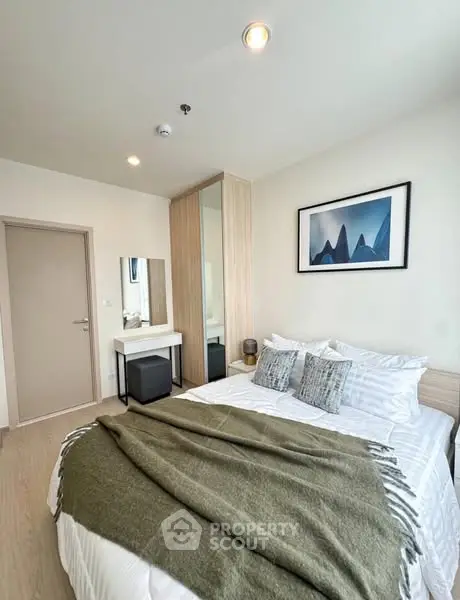 Cozy modern bedroom with stylish decor and ample natural light