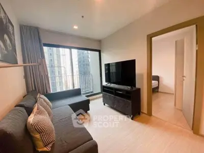 Modern living room with large TV and city view balcony in a stylish apartment.