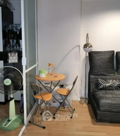 Cozy living room with modern decor, featuring a compact dining set and stylish floor lamp.