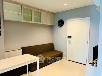 Modern living room with sleek furniture and wall-mounted storage in a cozy apartment.
