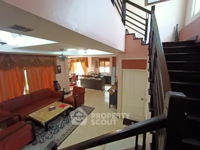 Spacious living room with elegant staircase and natural light