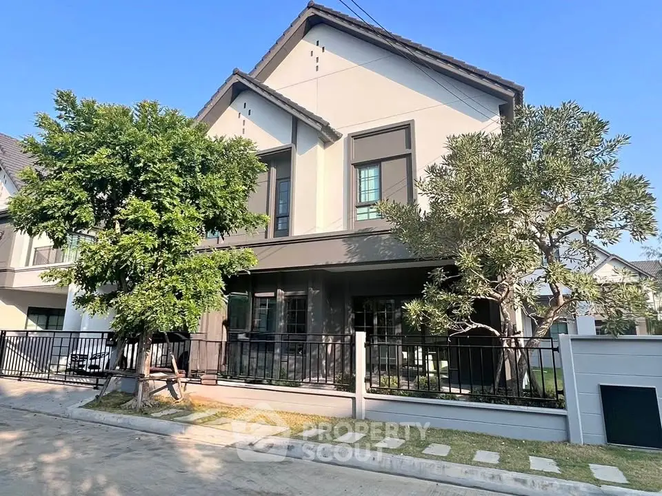 Charming two-story house with lush greenery and modern design in a serene neighborhood.
