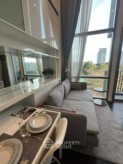 Modern living room with floor-to-ceiling windows and stylish decor in a high-rise apartment.