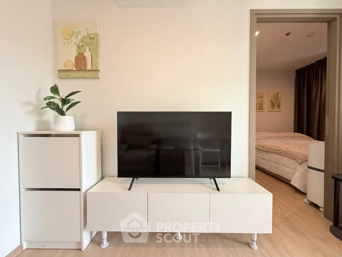 Modern living room with sleek TV stand and cozy bedroom view