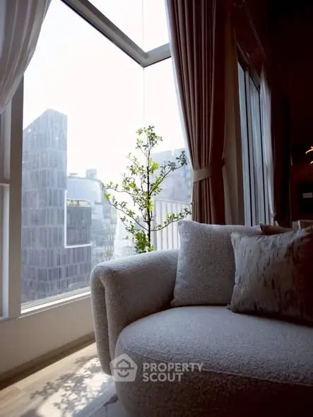 Luxurious living room with plush sofa and panoramic city view through large windows.