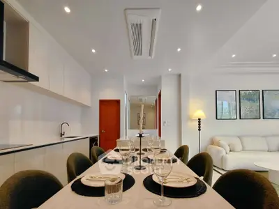 Modern dining area with elegant table setting and cozy living room ambiance.