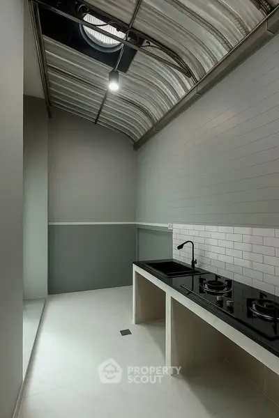 Modern kitchen with sleek design and gas stove under stylish ceiling.