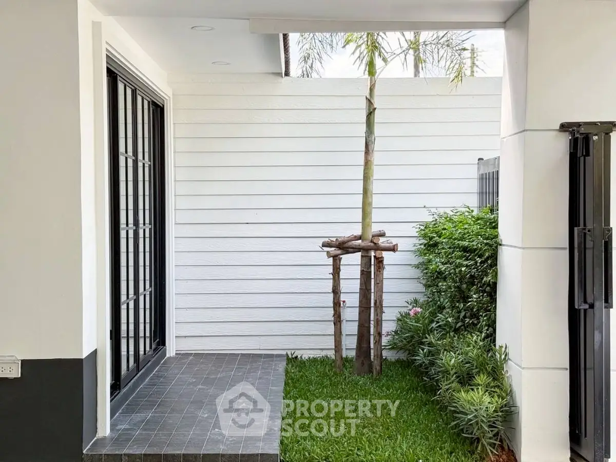 Modern home entrance with sleek design and lush greenery