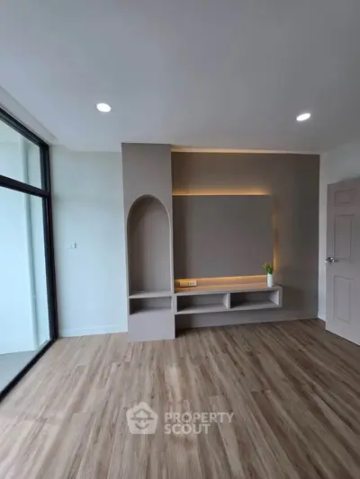 Modern living room with elegant built-in shelving and large windows for natural light.