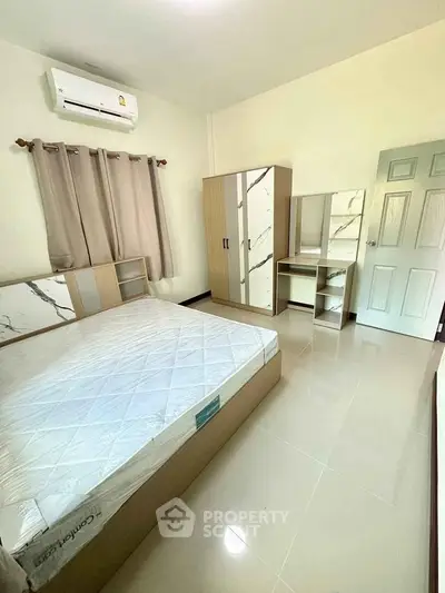 Spacious bedroom with modern furniture and air conditioning, perfect for comfort and relaxation.
