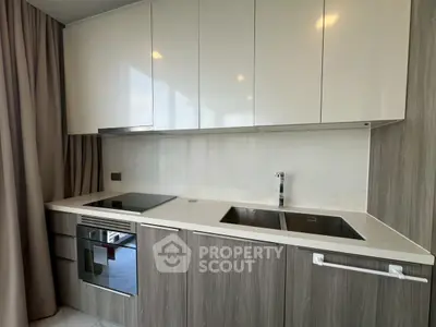 Modern kitchen with sleek cabinetry and built-in appliances in a stylish apartment.