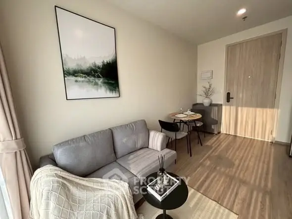 Modern living room with cozy sofa and dining area, featuring stylish decor and natural light.