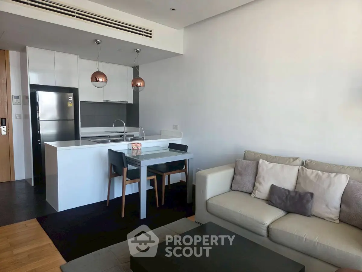 Modern living room with open kitchen and stylish decor in a contemporary apartment.