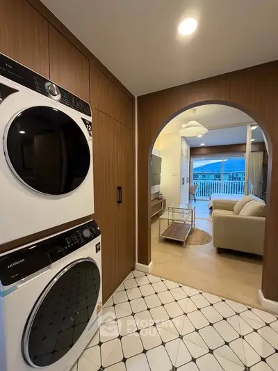 Modern apartment interior with washer and dryer, open living room, and stylish decor.