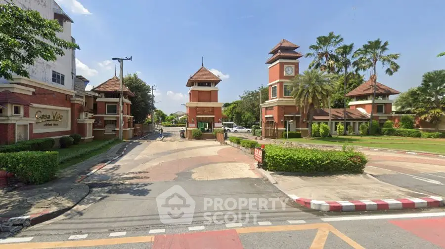 Charming gated community entrance with lush greenery and classic architecture.