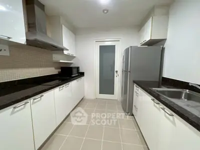 Modern kitchen with sleek white cabinets and stainless steel appliances