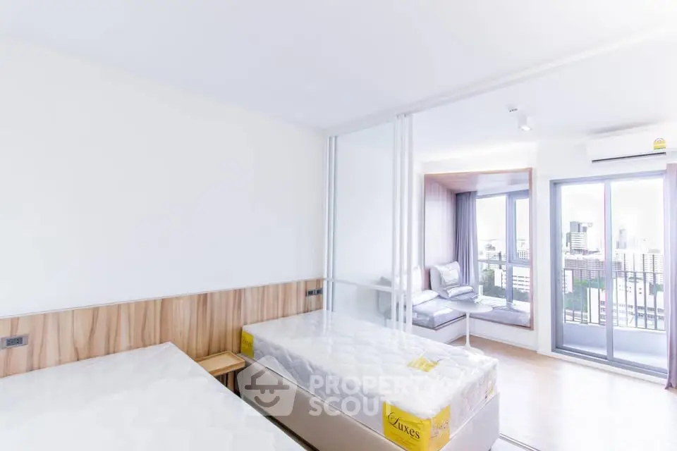 Bright modern bedroom with two beds and city view balcony