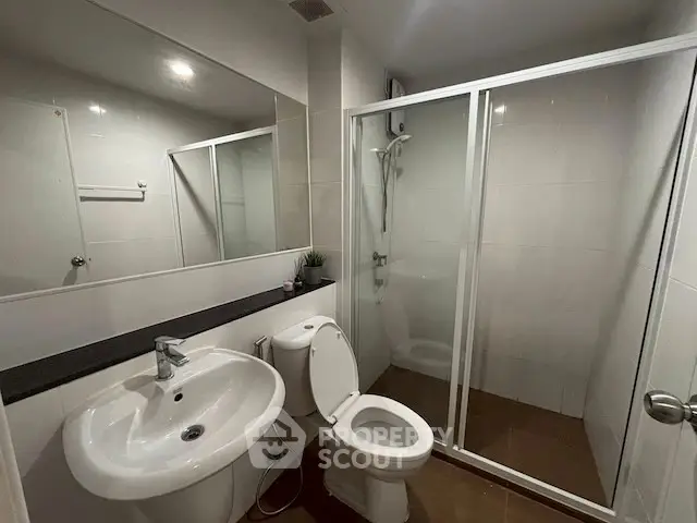 Modern bathroom with glass shower and sleek fixtures.