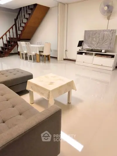 Spacious living room with modern furniture and elegant staircase