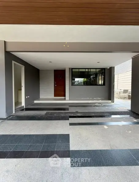 Modern home entrance with sleek design and spacious driveway
