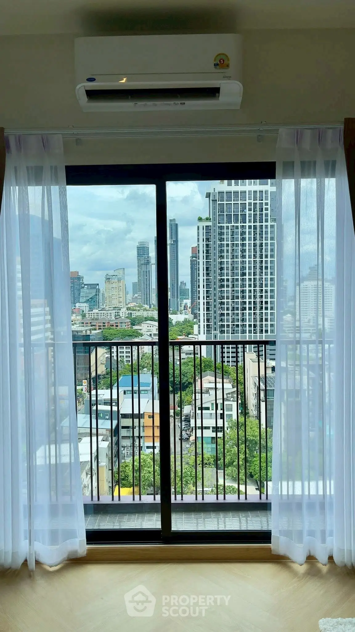 Stunning city view from modern apartment balcony with floor-to-ceiling windows and air conditioning.