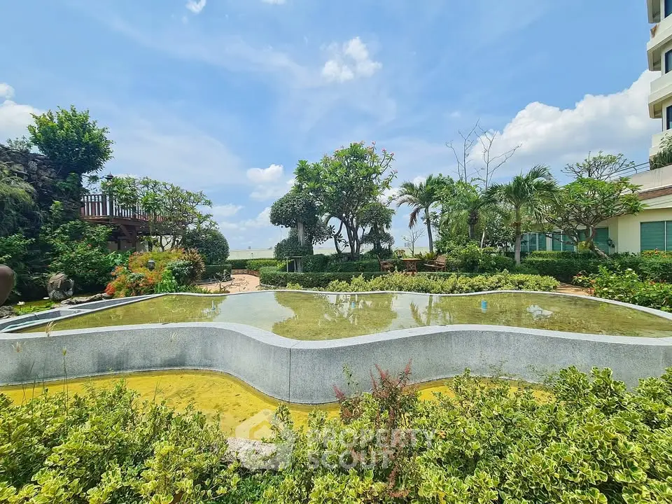 Luxurious garden view with serene water feature and lush greenery in a high-end residential complex.