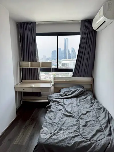 Cozy bedroom with city view, featuring a single bed and study desk, perfect for urban living.
