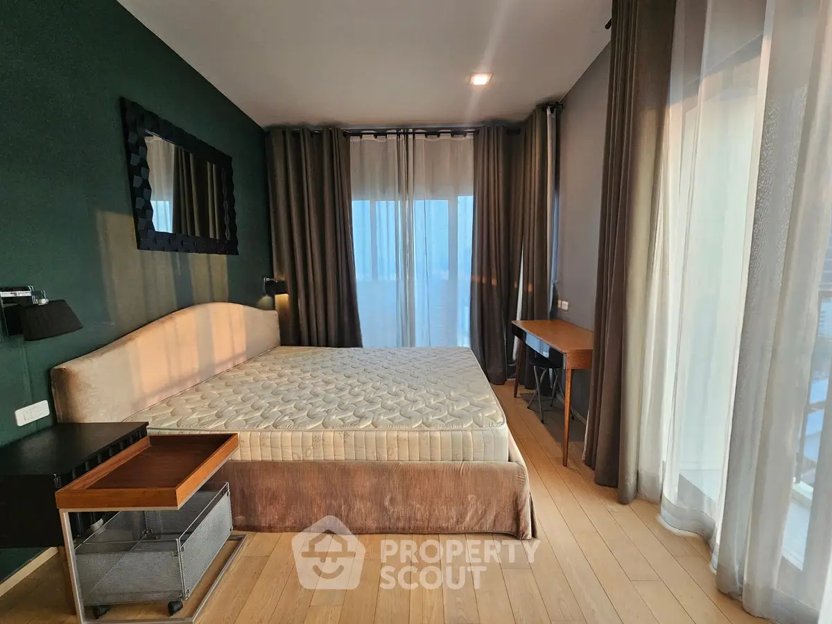 Spacious bedroom with modern decor and large windows offering natural light.