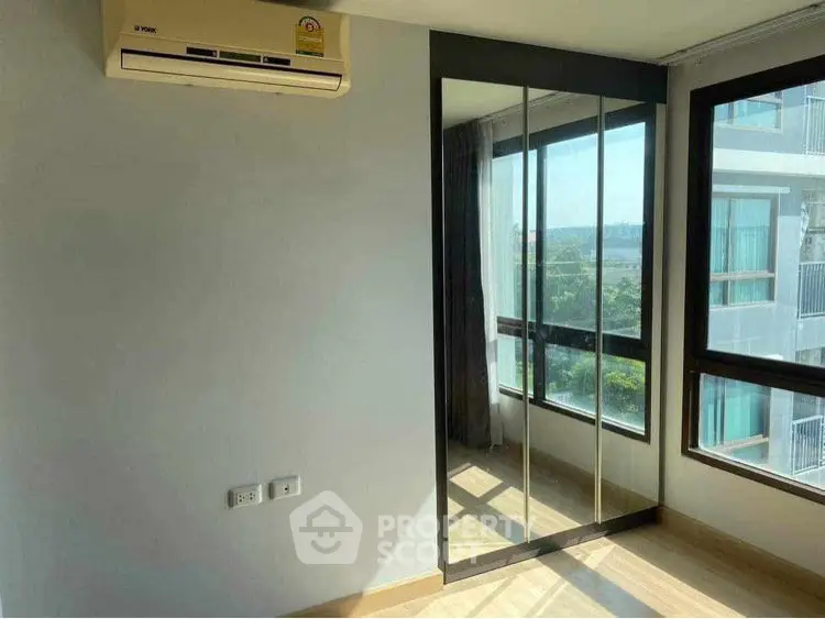 Bright bedroom with mirrored wardrobe and air conditioning, offering a scenic view.