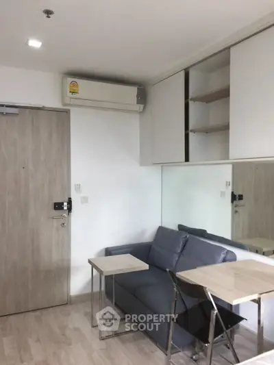 Modern living room with sleek furniture and built-in storage, featuring a cozy sofa and stylish tables.