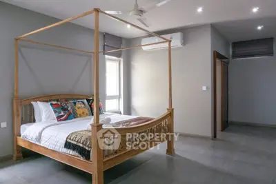 Spacious bedroom with elegant wooden canopy bed and modern decor
