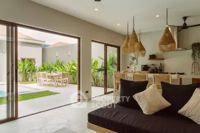 Luxurious open-plan living room with seamless indoor-outdoor flow to a lush garden and pool area.
