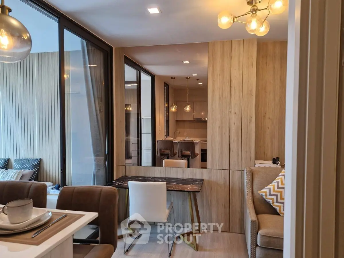 Modern open-plan living and dining area with stylish lighting and wooden accents.