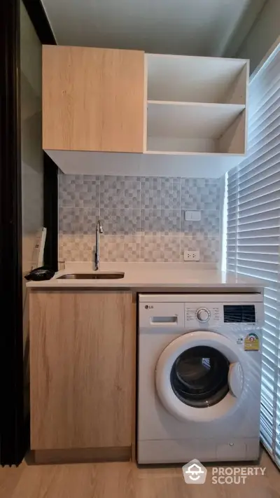 Compact kitchen with washing machine and modern cabinetry