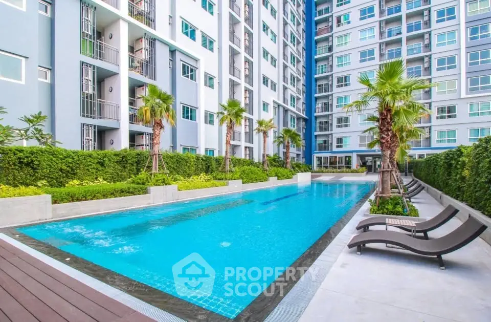 Luxurious modern apartment complex with inviting swimming pool and lush greenery.