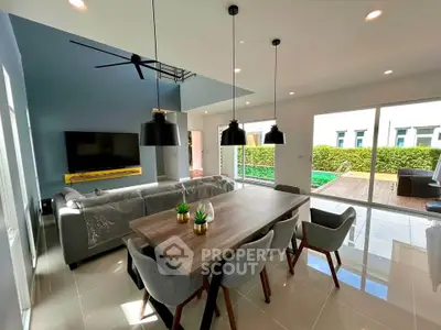 Modern living room with stylish dining area and pool view, featuring sleek furniture and abundant natural light.