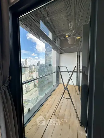 Stunning high-rise balcony with panoramic city views and modern glass railing.