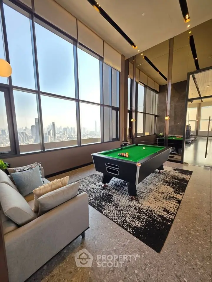Luxurious high-rise living room with pool table and stunning city skyline view.