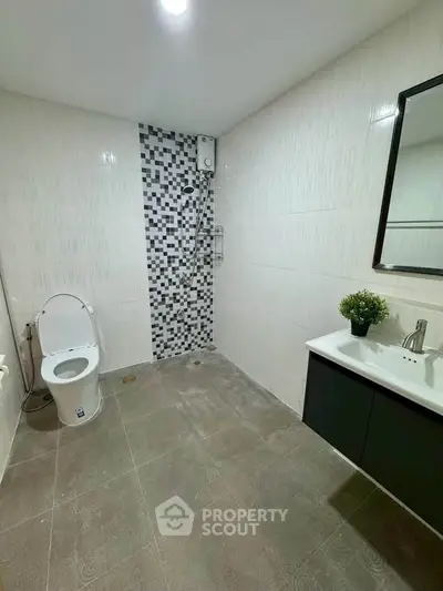 Modern bathroom with sleek design, featuring a stylish vanity and contemporary fixtures.
