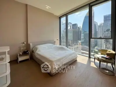 Luxurious bedroom with stunning city view and floor-to-ceiling windows in modern high-rise apartment.