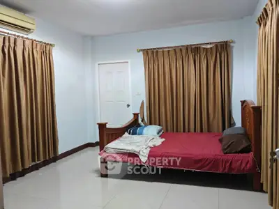 Spacious bedroom with elegant curtains and air conditioning, perfect for comfort and relaxation.